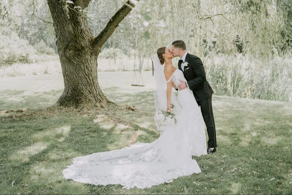 bride and groom kissing on the grounds of Perona Farms in Andover, NJ