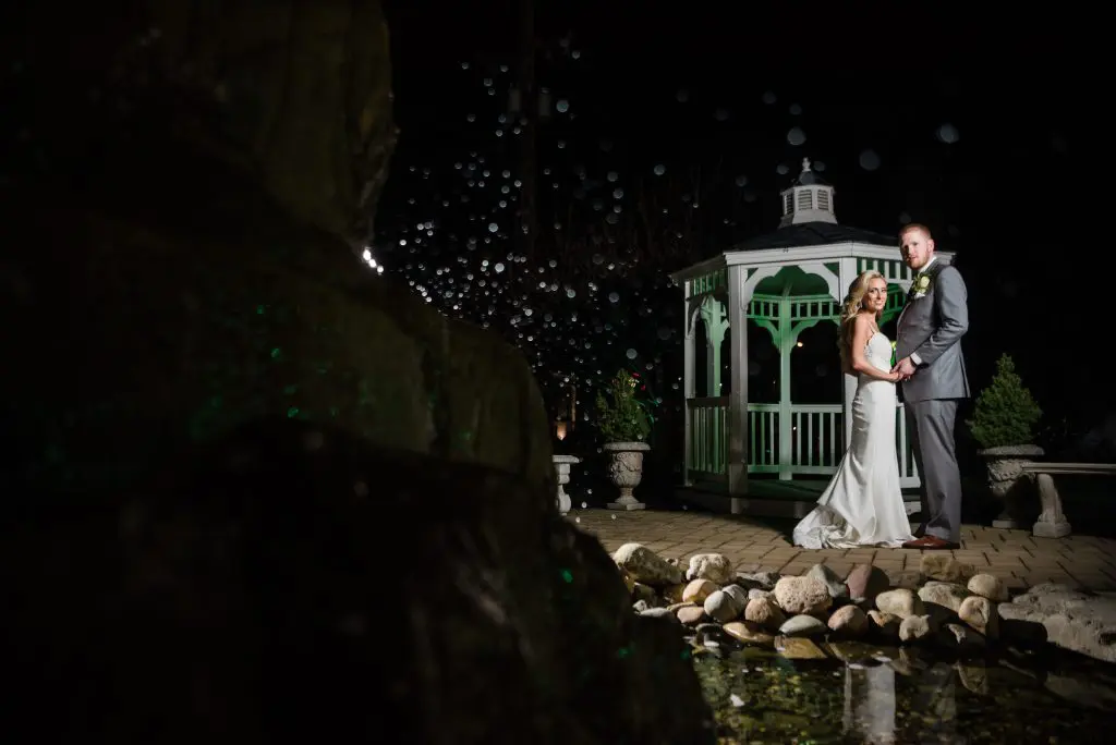 Bride and groom at night at pergola