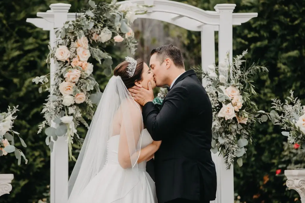 Bride and groom kissing outside
