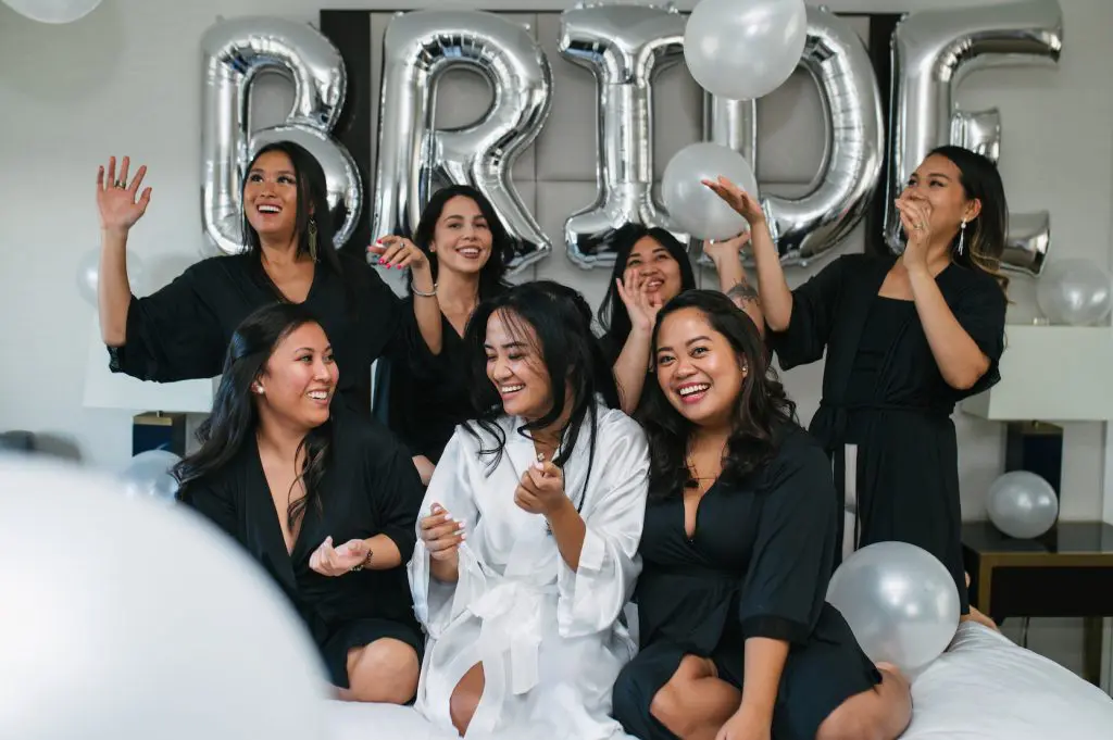 Bride with bridesmaids on bed