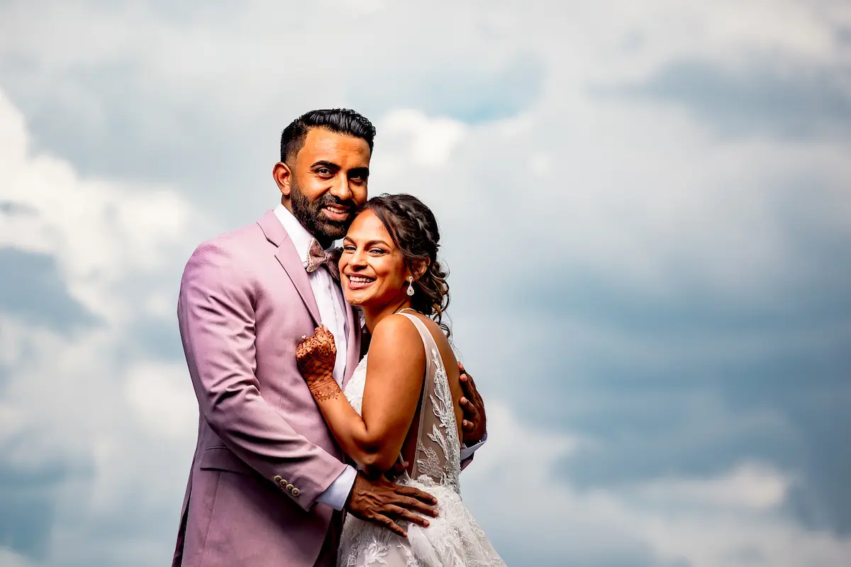 Bride and groom with cloudy sky