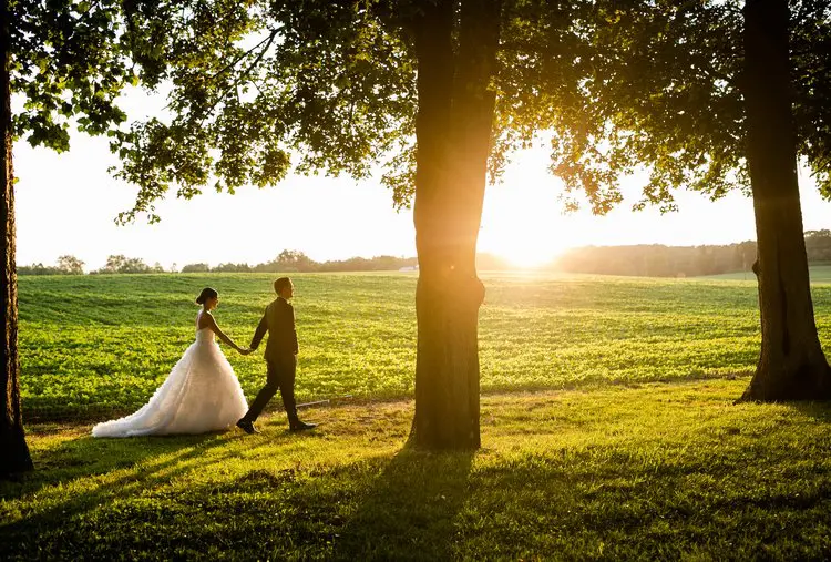 Bride and groom walking as sun sets