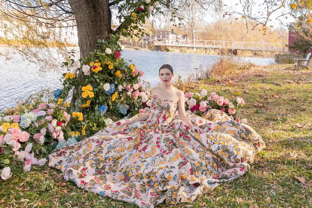 Bride sitting riverside at Red Mill Museum Village
