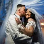 Groom kissing bride with veil over heads at wedding at The Grand in Totowa, NJ