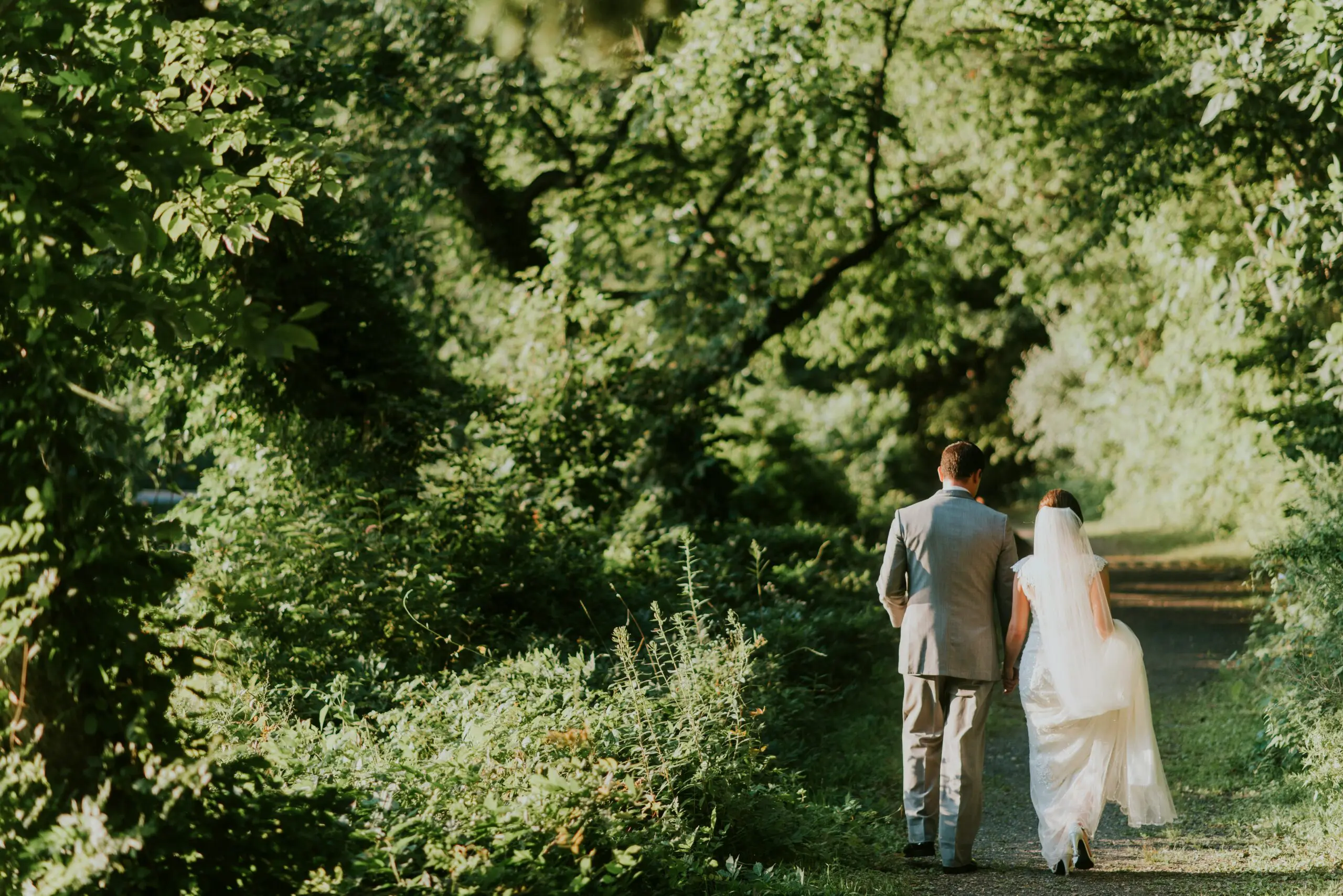 Wedding couple walking on path in woods