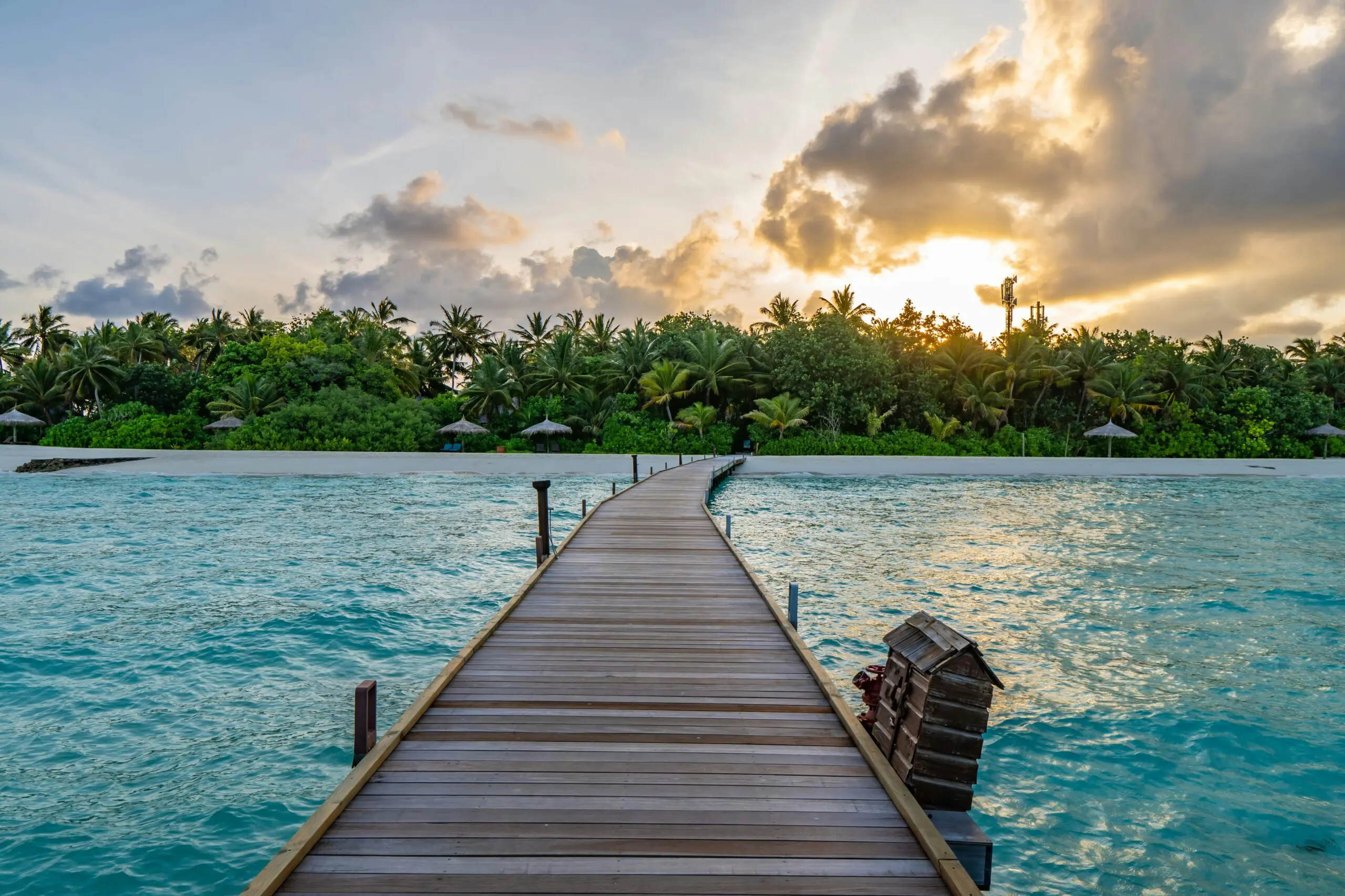 Brown wooden dock on blue sea under white clouds during daytime