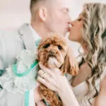Bride and groom kissing with dog at wedding at Crystal Point Yacht Club in Point Pleasant, NJ