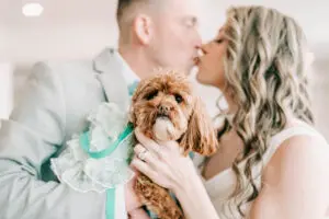 Bride and groom kissing with dog at wedding at Crystal Point Yacht Club in Point Pleasant, NJ