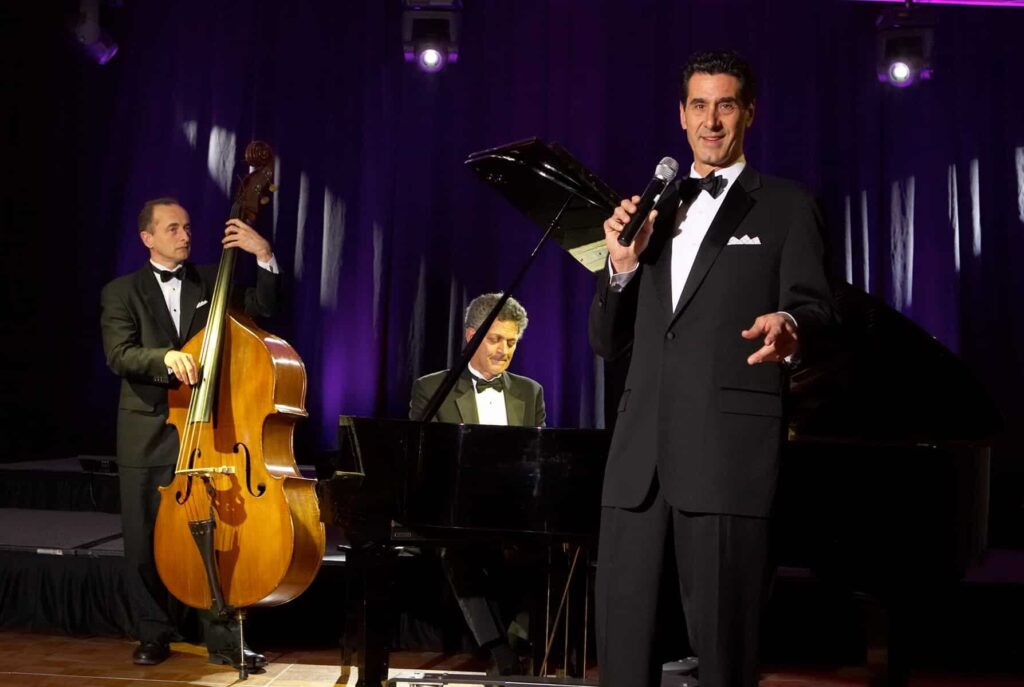 Man singing at wedding with celloist and pianist