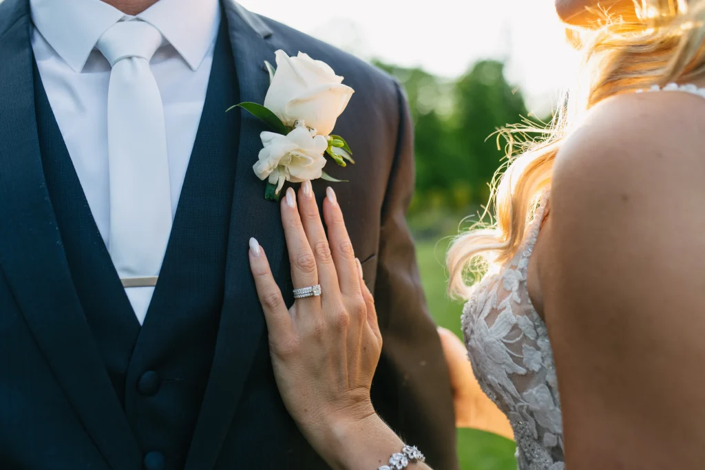Bride's hand on grooms jacket